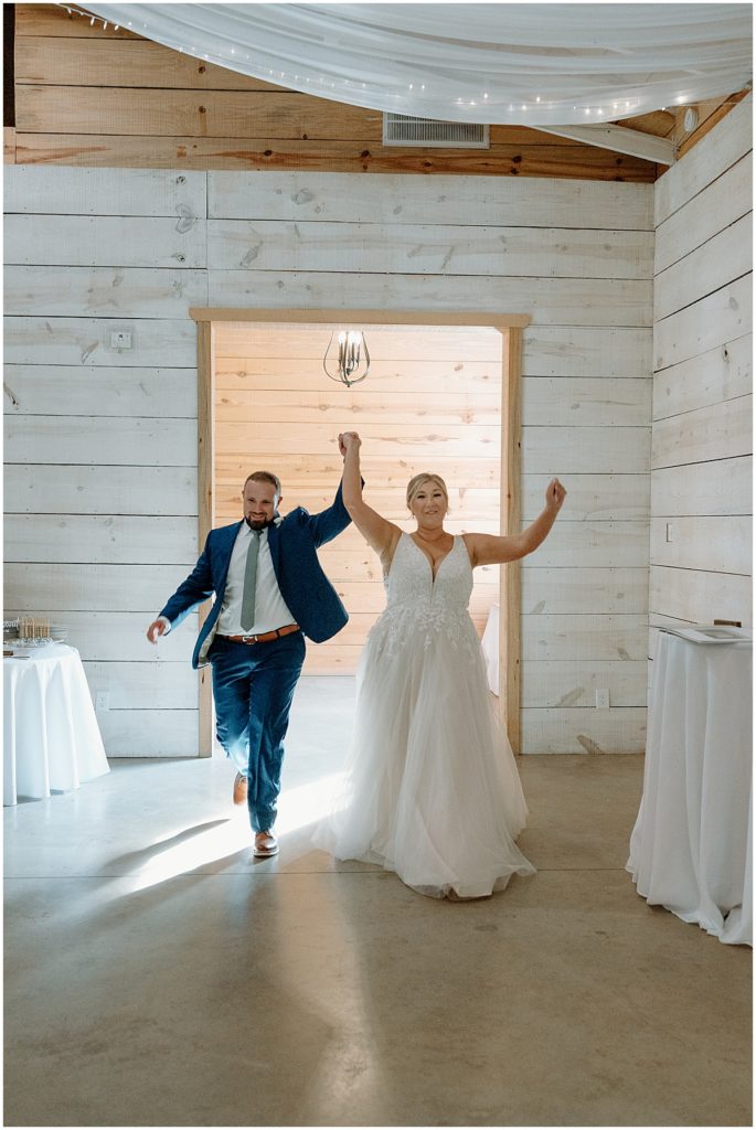 Bride and groom entering the wedding reception at this dreamy wedding at koury farms