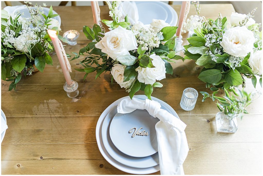 Wedding table decor with baby blue plates, delicate florals, ivory napkin and gold name plates