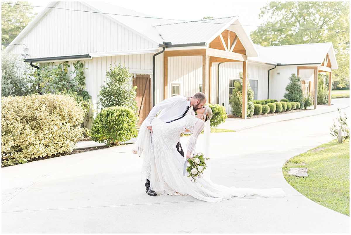 Bride and groom kissing infront of the main entrance at Koury Farms, a rustic and elegant wedding and event venue