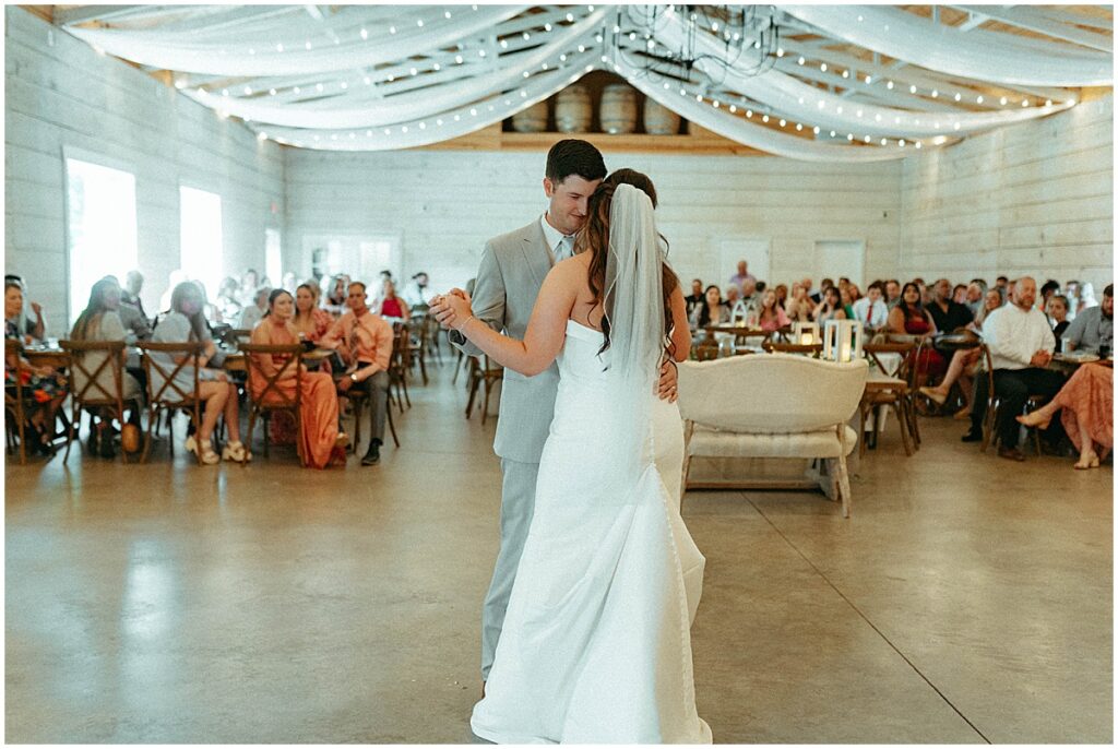 bride and groom first dance at white barn wedding reception