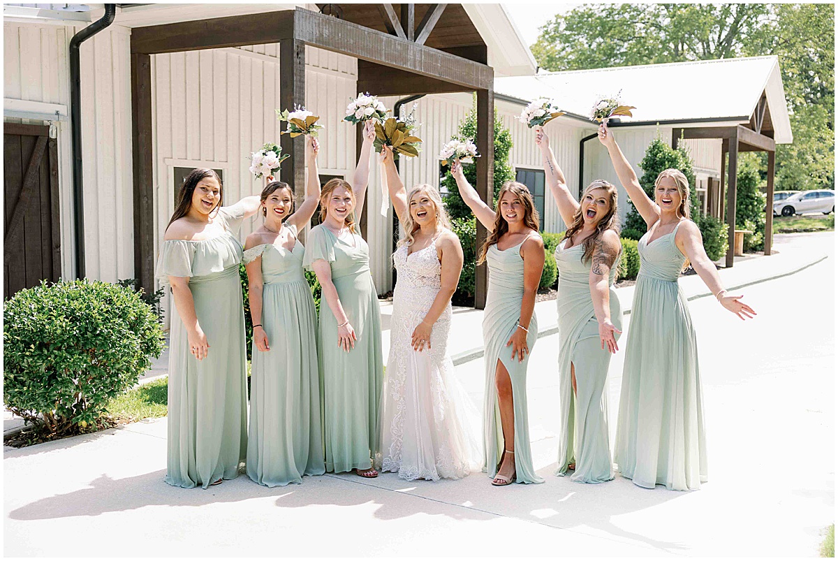 Bride with bridesmaids dressed in pale green dresses at green and white wedding