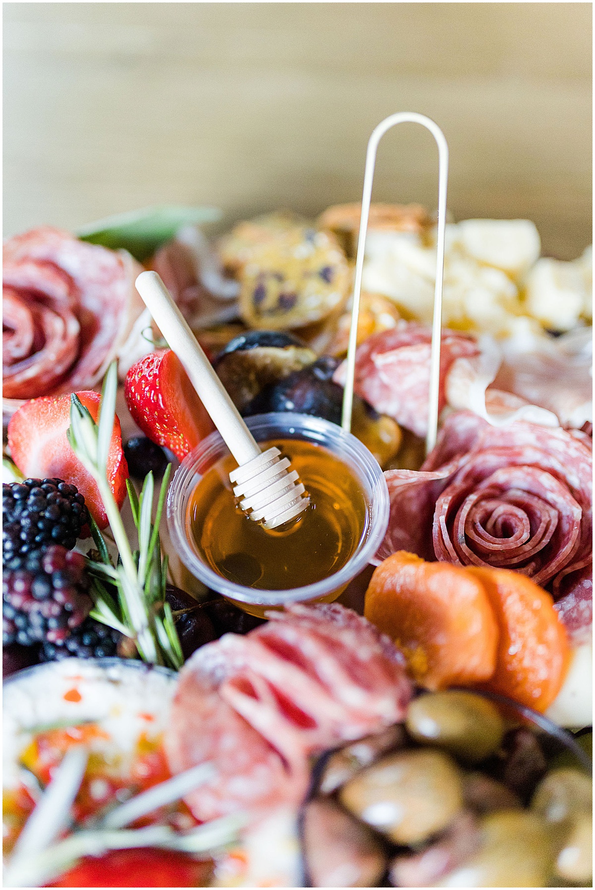 Charcuterie table with cheeses, meats, fruits and honey