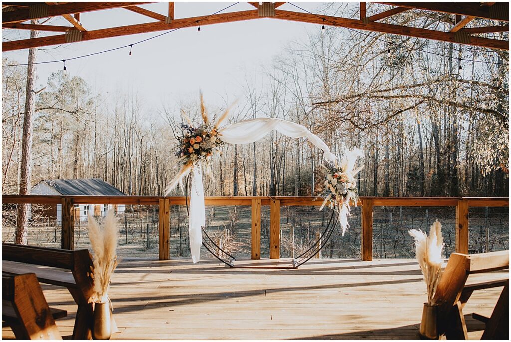 Circular wedding arch with blue, peach and ivory florals with pampas grass and white drapes for whimsical winter wedding at Koury Farms, North Georgia