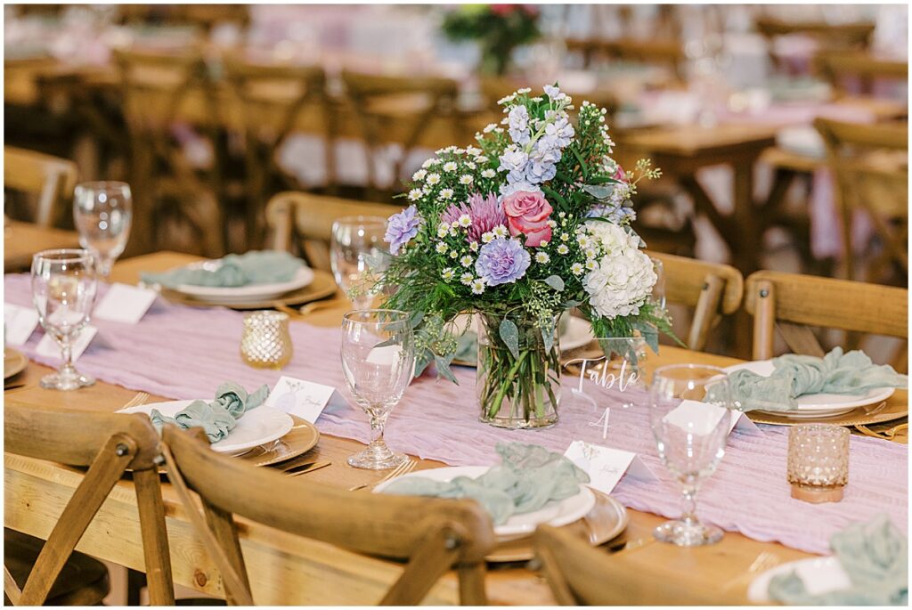 pink, blue, ivory, green florals set upon a table with pink table runner and gold accents