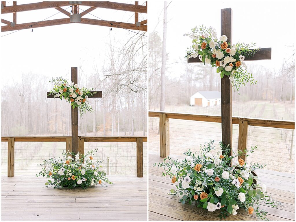 Wedding ceremony centerpiece of cross with green and orange florals