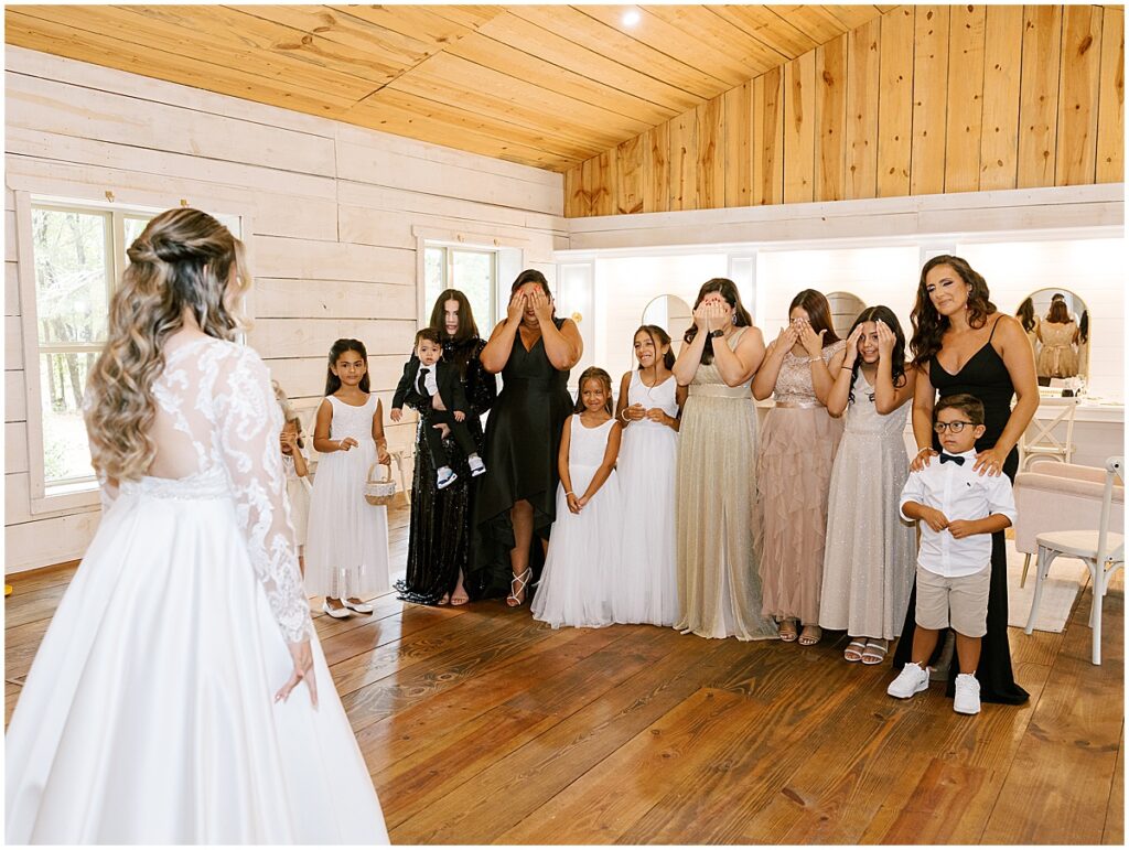 Bride revealing herself to friends and family at black, white and champagne wedding