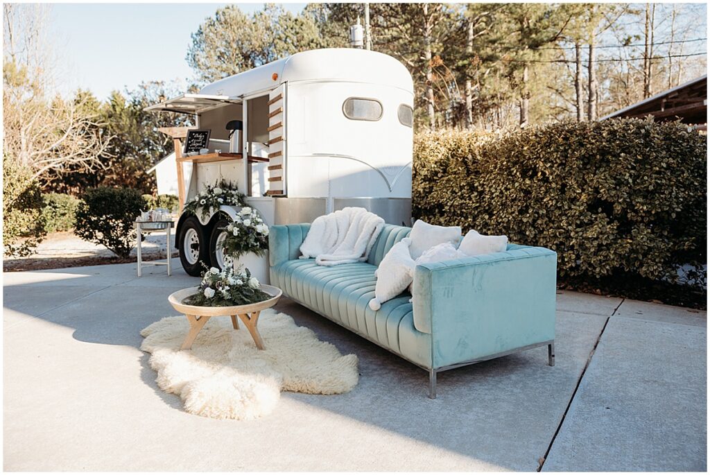 mobile bar and sofa area with pillows, blankets and fur rug for cozy winter wedding in North Georgia