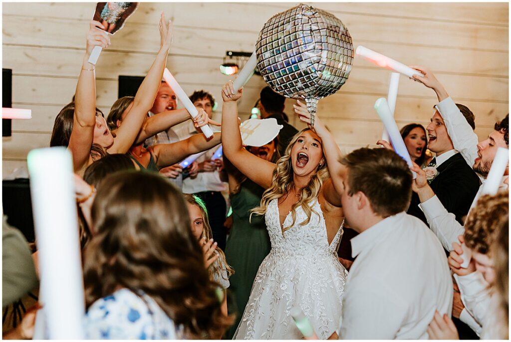 Bride in the middle of guests dancing at wedding reception at Koury farms