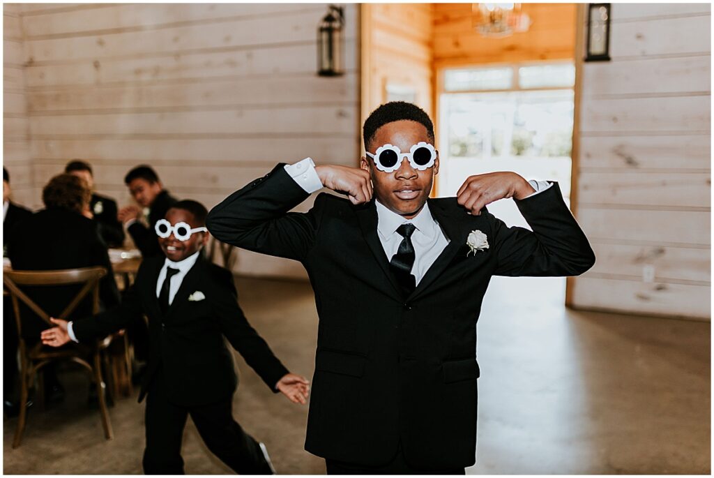 Boys wearing sunglasses walking into wedding reception