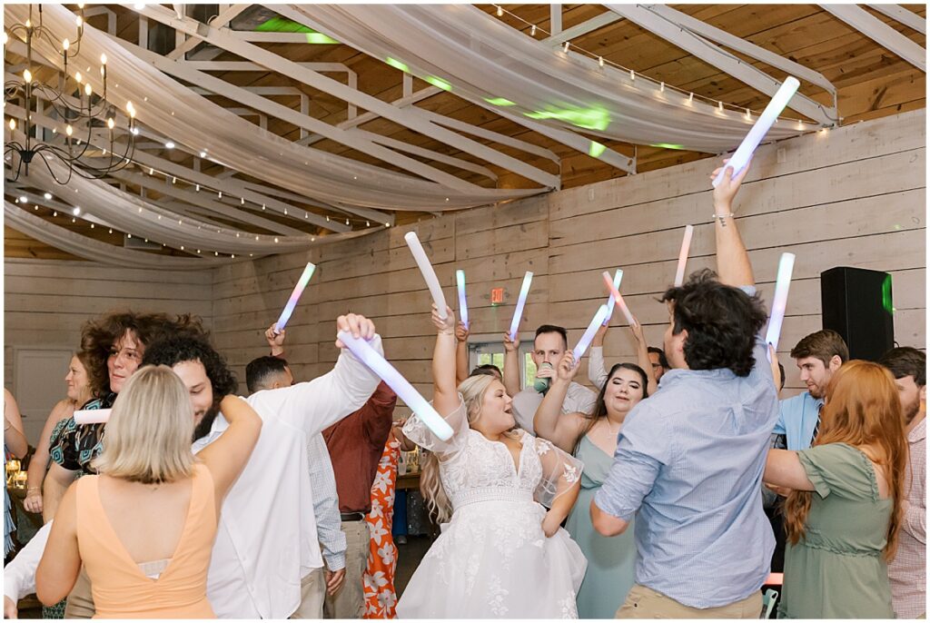 Guests dancing at wedding reception with glowsticks