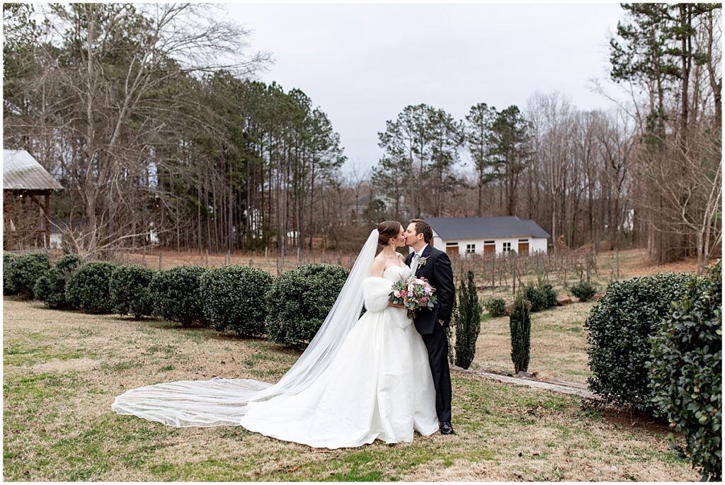 Bride and groom kissing in grounds of Koury Farms wedding venue