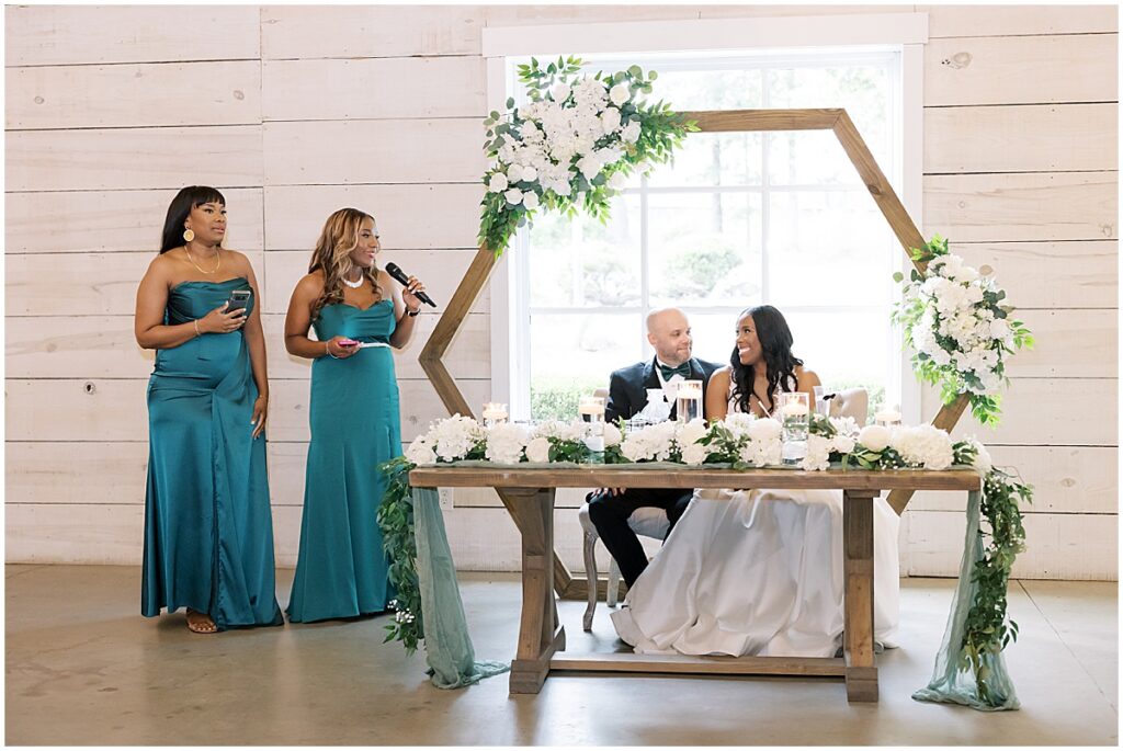 Bride and groom sat at sweetheart table at emerald green wedding reception, Koury Farms