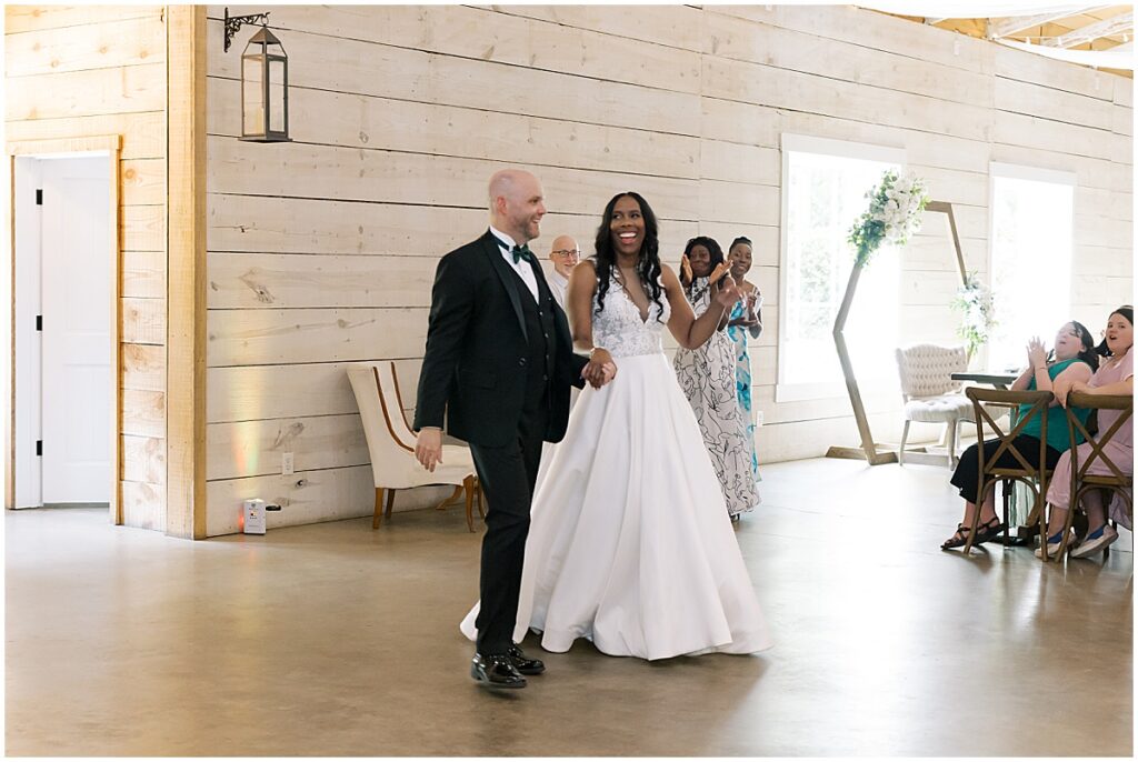 Bride and groom entering wedding reception at Kour Farms