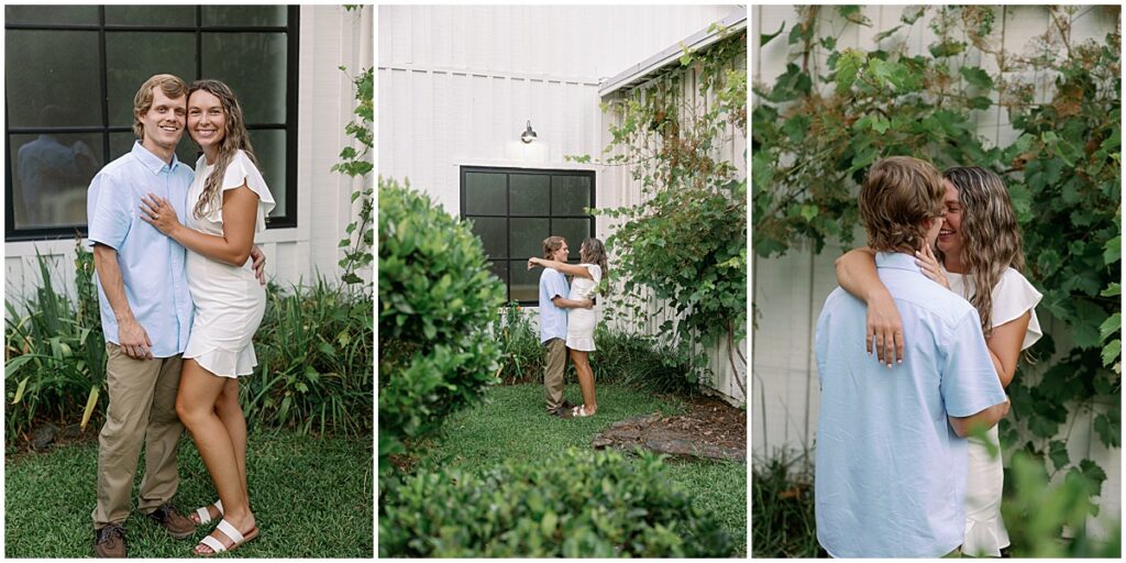 Women wearing white dress and man wearing blue shirt and beige slacks in romantic poses against a white barn backdrop with green foliage