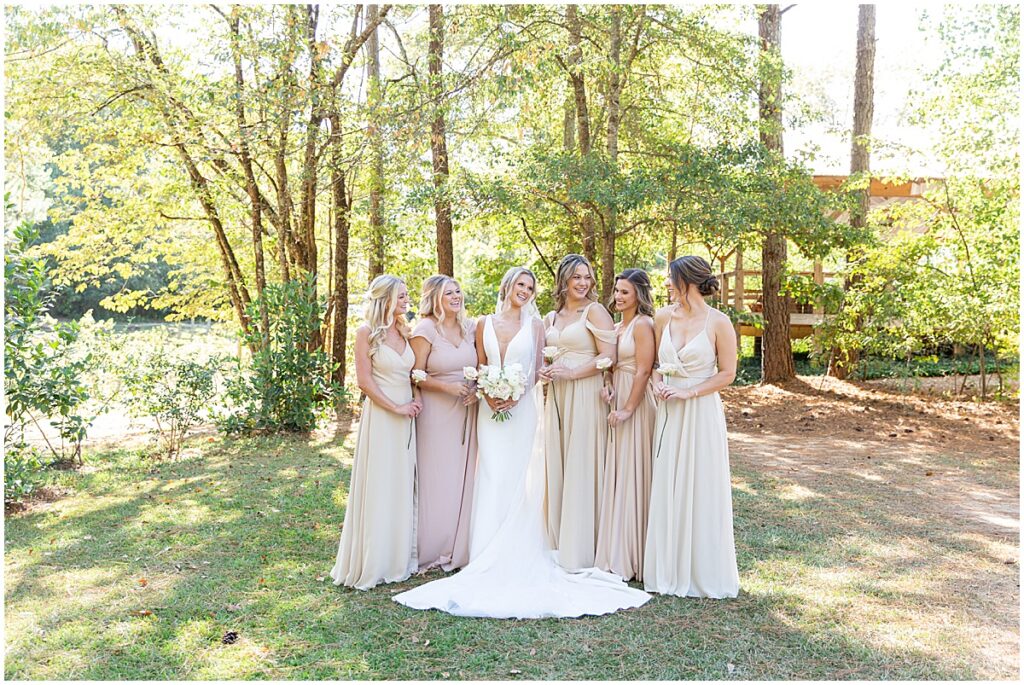 Bride with bridesmaids wearing cream dresses for a neutral wedding color palette