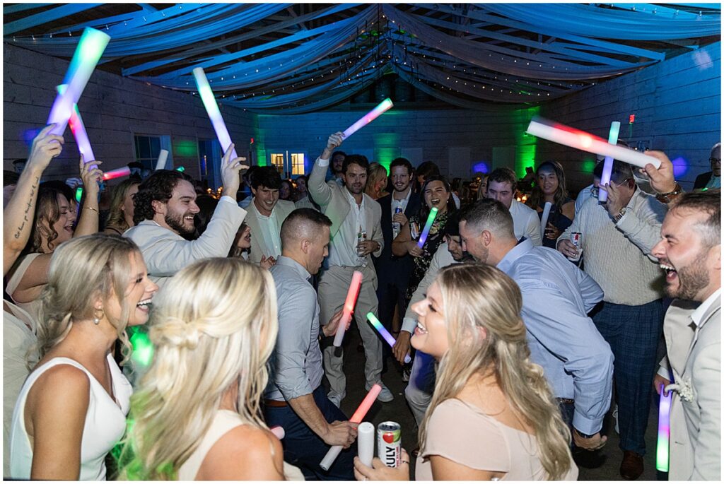 Wedding guests with glow sticks at wedding reception