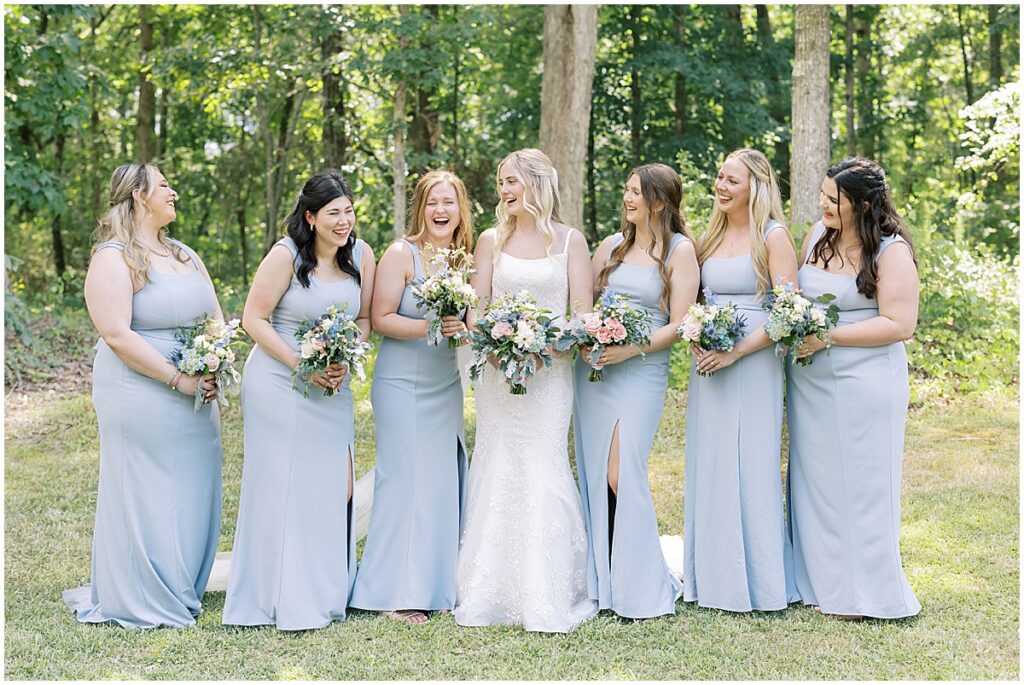 Bride with bridesmaids wearing pale blue dresses at summer vineyard wedding at Koury Farms