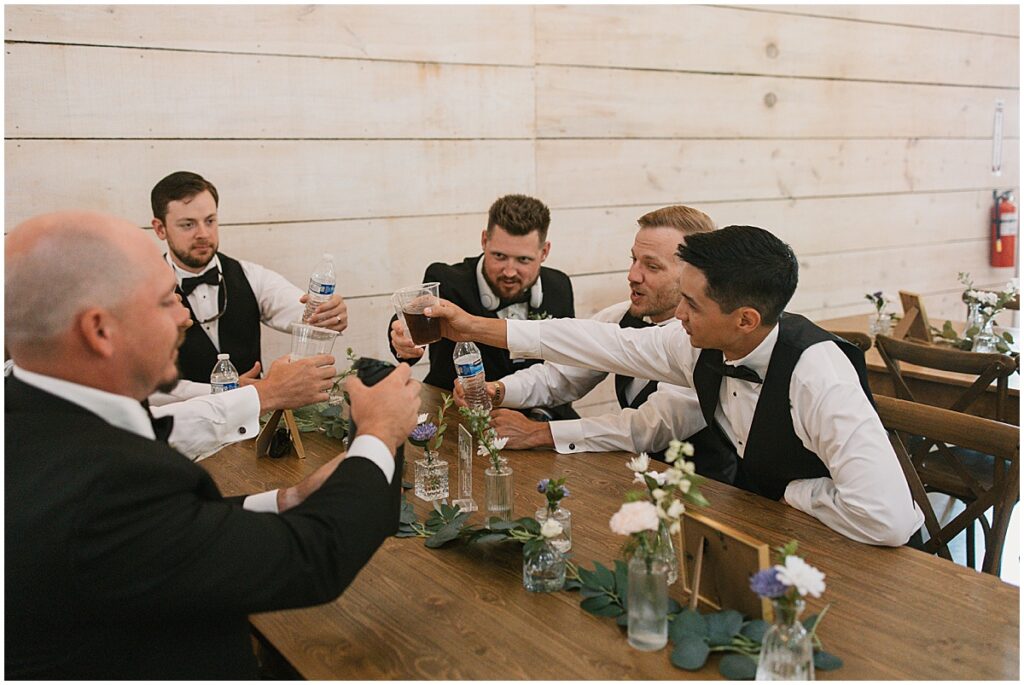 Grooms men cheersing with drinks before wedding at Koury Farms