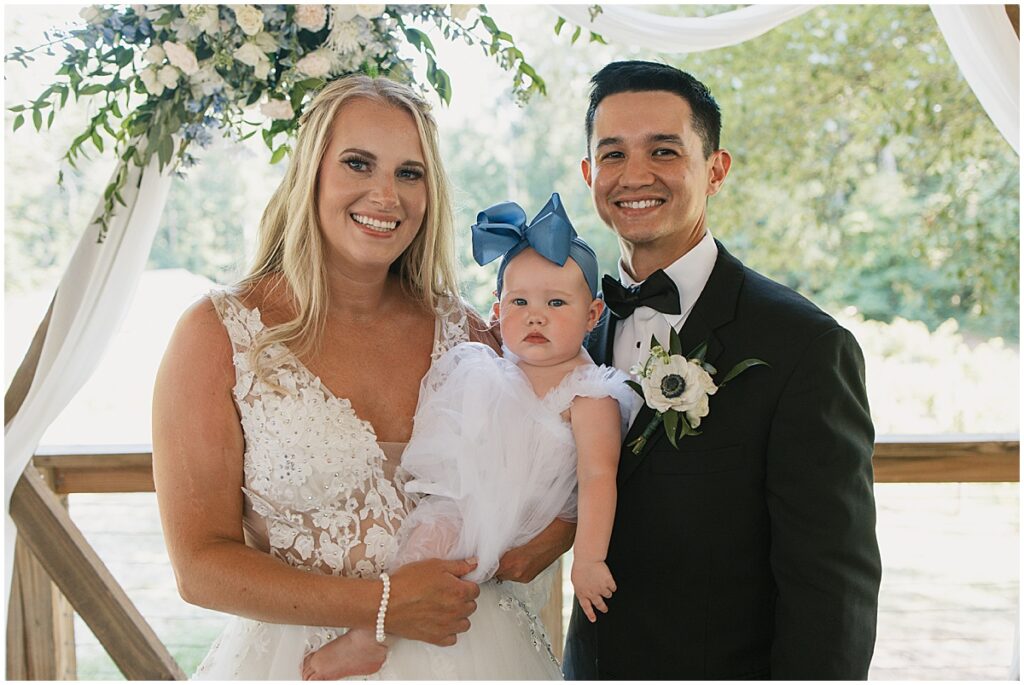 Bride and groom with baby at Koury Farms wedding