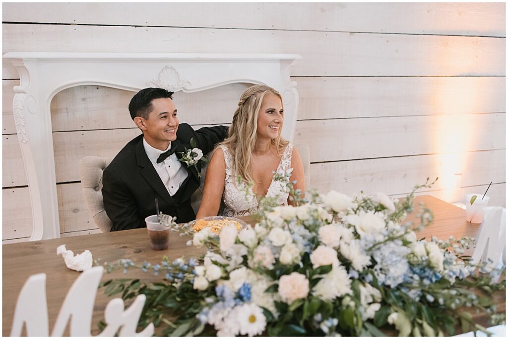 Bride and groom sitting at sweet heart table at elegant fairytale wedding at Koury Farms