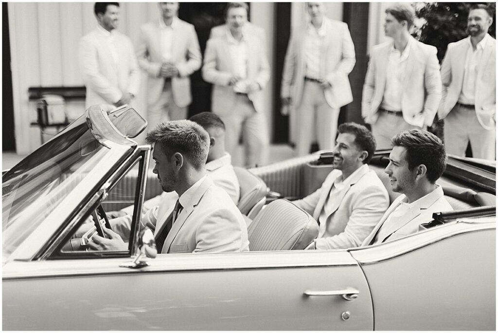 Groom with groomsmen in vintage car