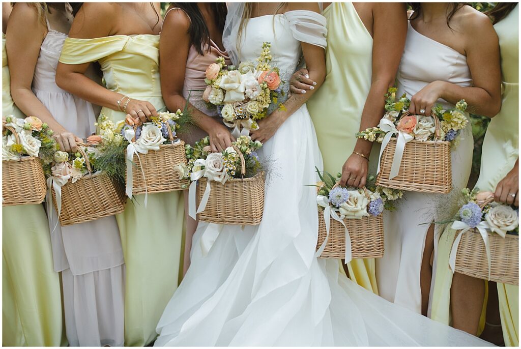 Bride with bridesmaids holding baskets of flowers