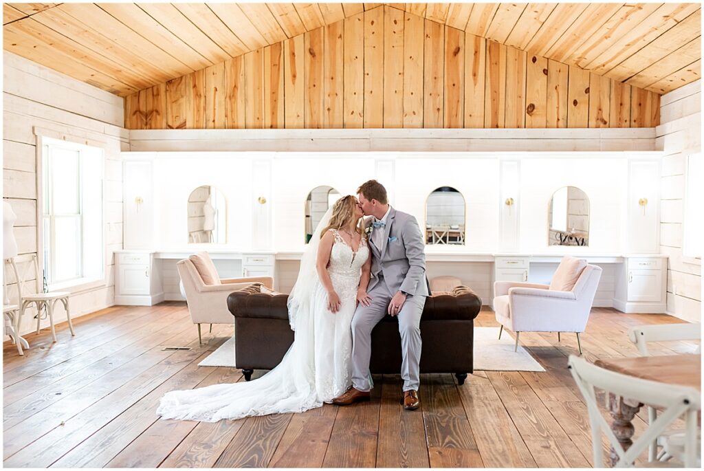 Bride and groom sitting on edge of couch at Bridal suite at Koury Farms