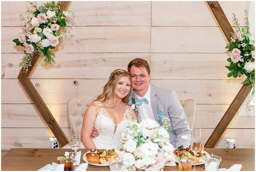 Bride and groom sitting at sweet heart table at Koury Farms