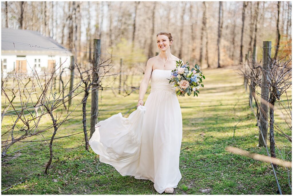 Bride walking through the vineyard at March wedding at Koury Farms