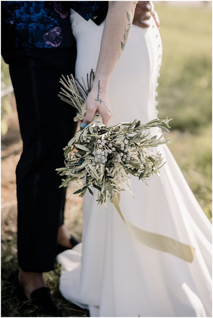 Bride holding floral bouquet of wild flowers and berries