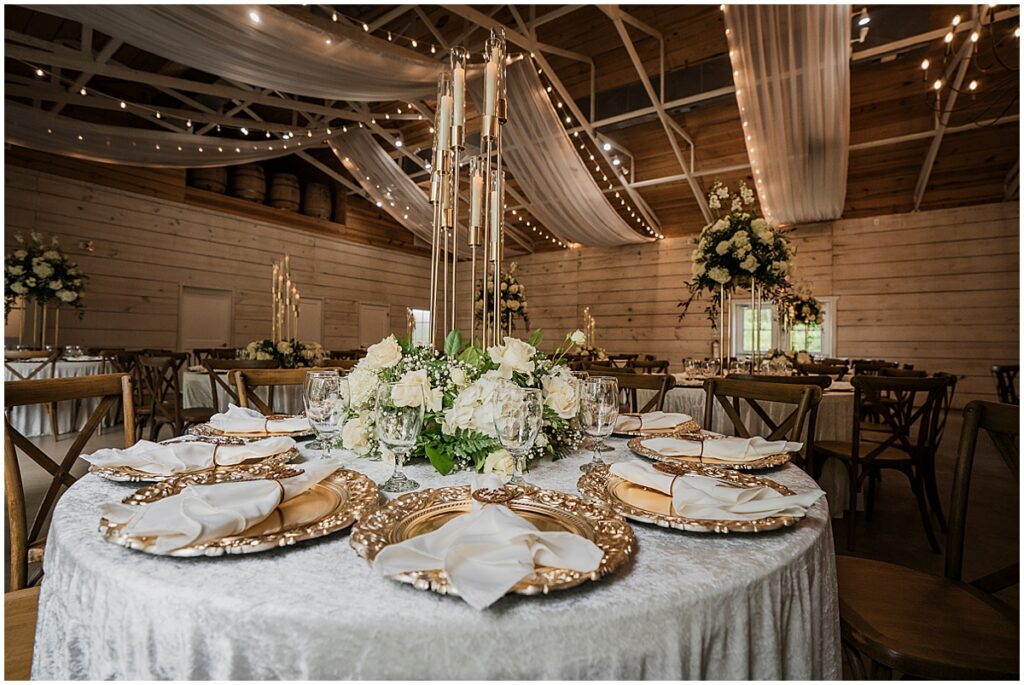 wedding table set up with tall candles, gold decor and personalized naplins