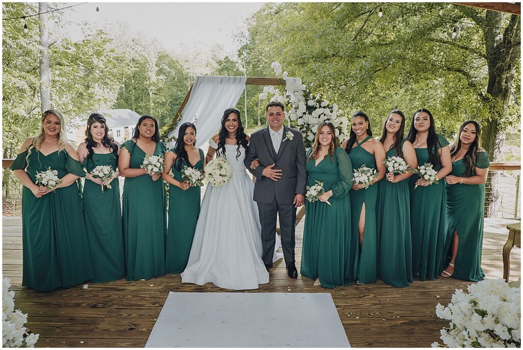 bride with bridesmaids in emerald green dresses