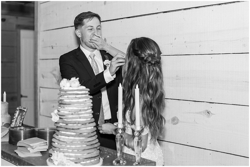 Bride and groom feeding each other after cutting cookie cake