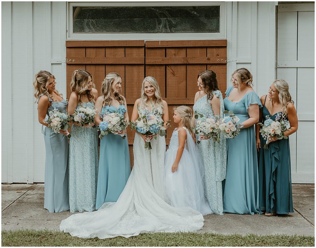 bride with bridesmaids all in blue dresses