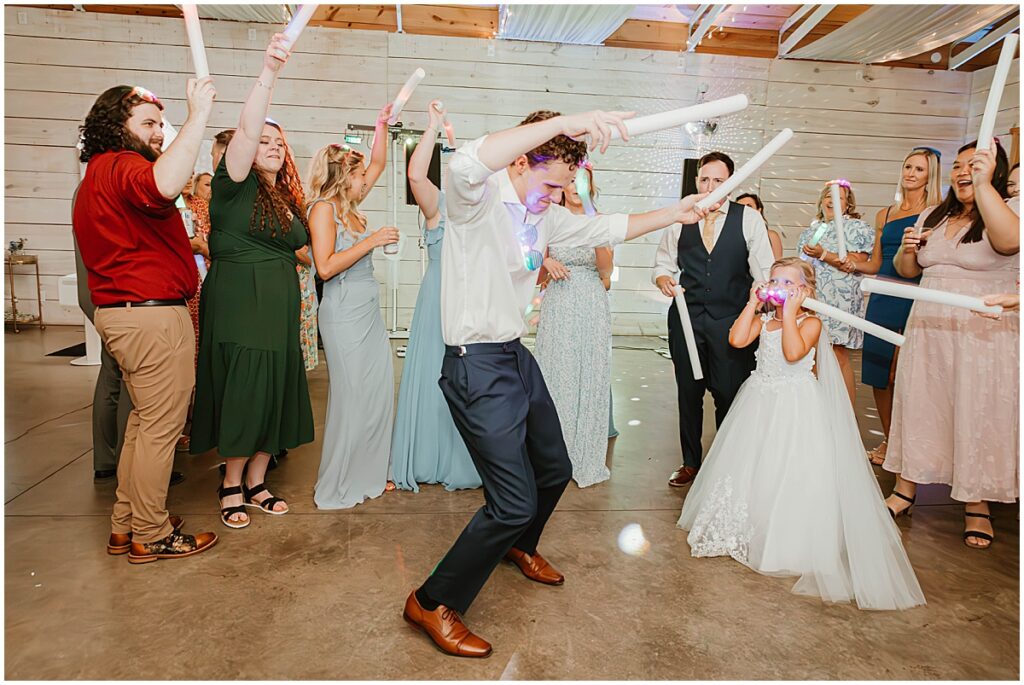 wedding guests dancing at wedding reception with glow sticks